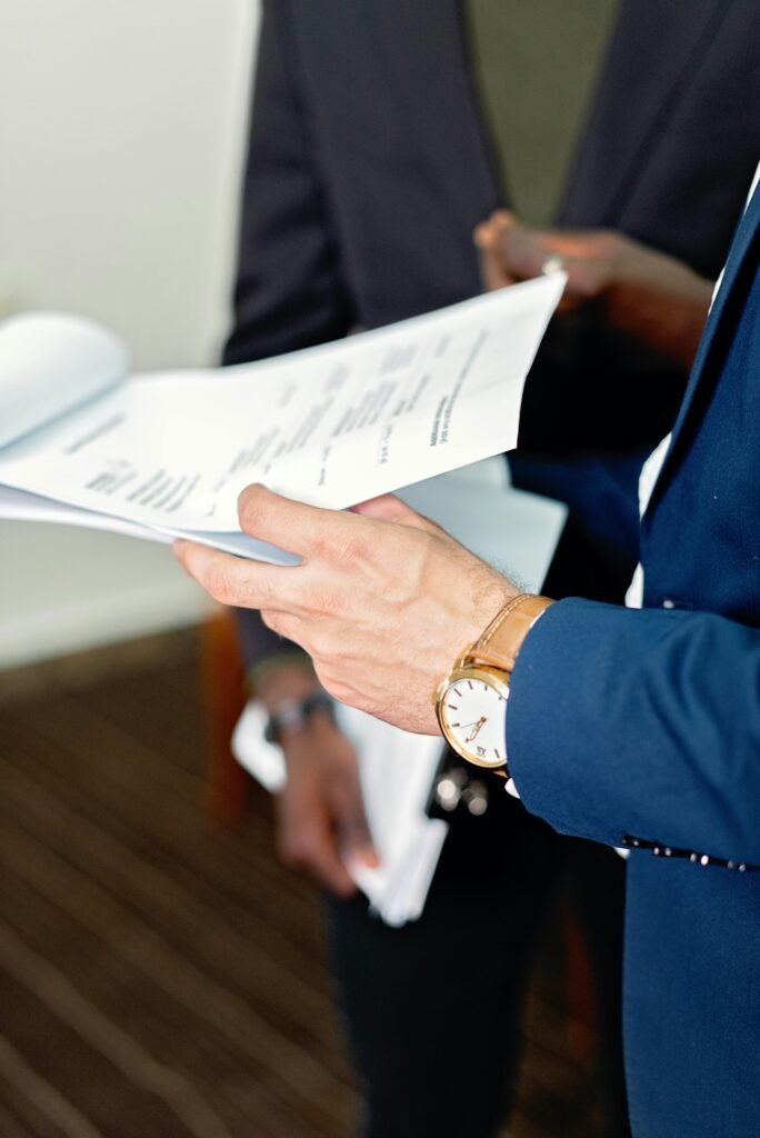 Close-up of professionals reviewing documents in a meeting, focusing on details and teamwork.
